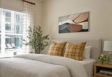 Katy apartment for rent - A bedroom with a large bed and a painting on the wall.