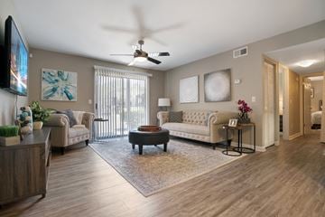 Jacksonville apartment for rent - A living room with a white couch and a television on the wall.
