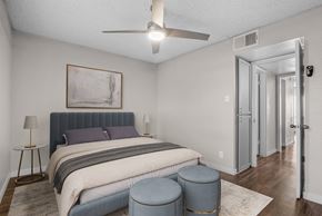 Mesa apartment for rent - A bedroom with a bed, a painting, a lamp, and a ceiling fan.