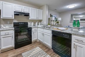 Stockbridge apartment for rent - A kitchen with white cabinets and black appliances.