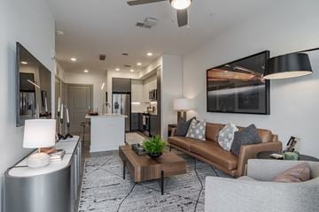 Atlanta apartment for rent - A modern living room with a brown leather couch and a coffee table.