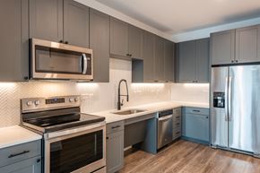 Dallas apartment for rent - a kitchen with gray cabinets and white countertops