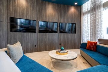 Humble apartment for rent - A living room with a white couch and a blue cushion.