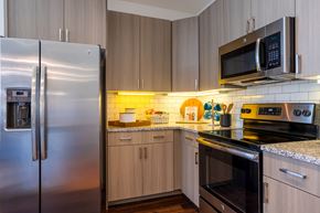 Humble apartment for rent - A kitchen with a stainless steel refrigerator and a microwave oven.