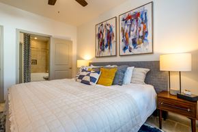 Humble apartment for rent - A bedroom with a large bed and two abstract paintings on the wall.
