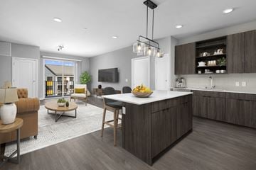 Brookfield apartment for rent - A modern kitchen with a large island and a living room area with a sofa and chairs.