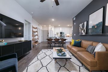 Jacksonville apartment for rent - A modern living room with a brown leather couch and a black and white rug.