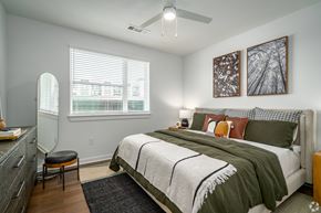 Houston apartment for rent - a bedroom with a bed and a ceiling fan