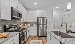 Burleson apartment for rent - a kitchen with white cabinets and stainless steel appliances