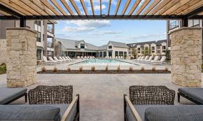 Burleson apartment for rent - a pool with lounge chairs and a building with a pool