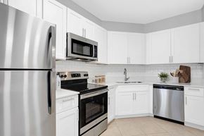 Jacksonville Beach apartment for rent - a kitchen with stainless steel appliances and white cabinets