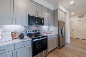 Houston apartment for rent - A modern kitchen with a stainless steel refrigerator and oven.
