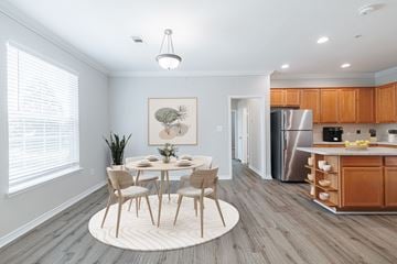 Conroe apartment for rent - A dining room with a table set for four and a kitchen in the background.