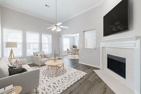 Conroe apartment for rent - A living room with a grey couch, a coffee table, and a fireplace.