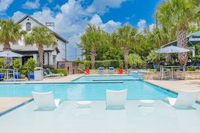 Pasadena apartment for rent - A pool with white chairs and a house in the background.