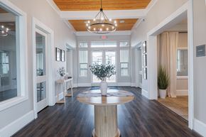 Pasadena apartment for rent - A large, round wooden table is at the center of a spacious room with a chandelier hanging from the ceiling.