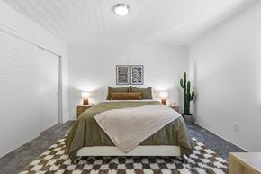 Yuma apartment for rent - A bedroom with a bed, two lamps, and a cactus.