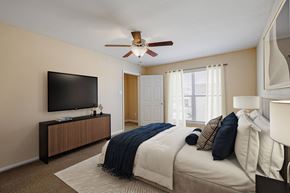 Houston apartment for rent - a bedroom with a large bed and a ceiling fan