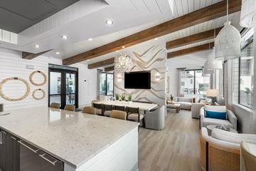 Scottsdale apartment for rent - A modern kitchen with a large island and a living area with a couch and chairs.
