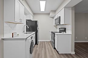 Phoenix apartment for rent - A modern kitchen with white cabinets and appliances.