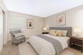 Dallas apartment for rent - A bedroom with a bed, chair, and two lamps.