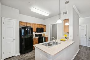 Stafford apartment for rent - A kitchen with black appliances and wooden cabinets.