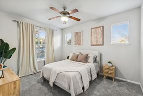 Stafford apartment for rent - A bedroom with a large bed, a ceiling fan, and a window with curtains.