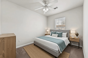 Killeen apartment for rent - A bedroom with a bed, nightstand, and a ceiling fan.
