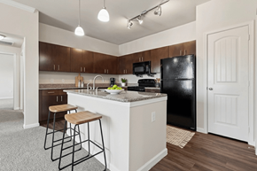 Buda apartment for rent - A kitchen with a black refrigerator and white countertops.