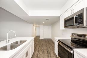 Naples apartment for rent - a kitchen with white cabinets and black appliances and a sink