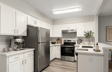 Riverside apartment for rent - A kitchen with white cabinets and stainless steel appliances.