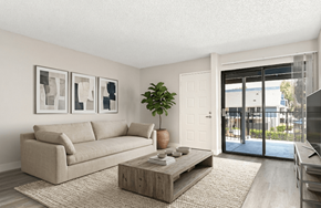 Riverside apartment for rent - A living room with a beige couch, a wooden coffee table, and a plant.
