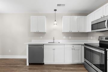 South Lyon apartment for rent - A modern kitchen with white cabinets and stainless steel appliances.
