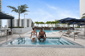 Miami apartment for rent - Two people are sitting in a pool on a sunny day.