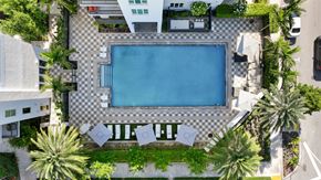 Fort Lauderdale apartment for rent - an aerial view of a swimming pool in a hotel with palm trees
