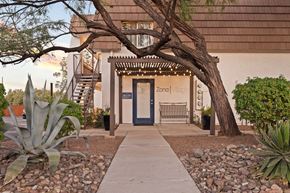 Tucson apartment for rent - A building with a blue door and a sign that says "Zona Vllage".