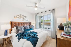Hockley apartment for rent - A bedroom with a white bed and a blue blanket.