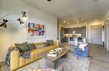 Austin apartment for rent - A living room with a yellow couch and a painting on the wall.