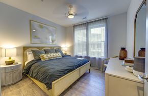 Austin apartment for rent - A bedroom with a bed, nightstand, and a painting on the wall.