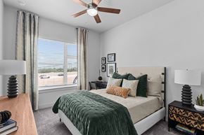 Austin apartment for rent - a bedroom with a large window and a ceiling fan