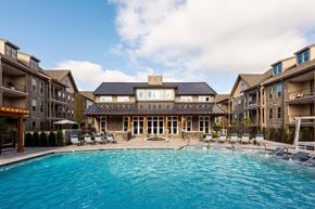 Franklin apartment for rent - A large swimming pool in front of a building with a covered patio area.