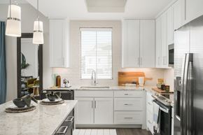 Arlington apartment for rent - A kitchen with white cabinets and a marble countertop.