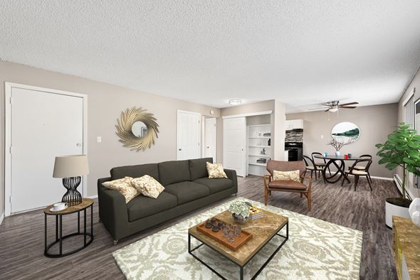 Aurora apartment for rent - A living room with a grey couch, a coffee table, and a dining table with chairs.