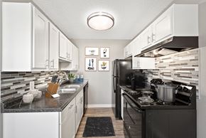 Aurora apartment for rent - A kitchen with black and white appliances and a black counter top.