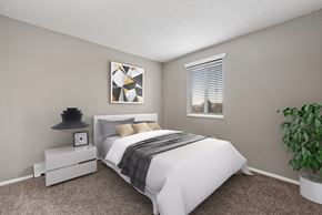 Aurora apartment for rent - A bedroom with a white bed and a plant on the side table.