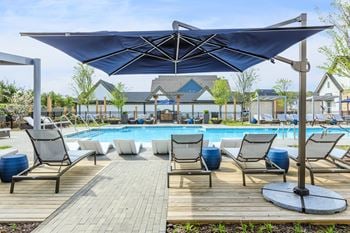 Shimmering swimming pool with sun shelf, poolside pavilion and a covered patio