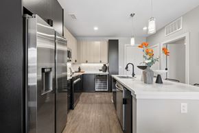 Denver apartment for rent - A modern kitchen with a stainless steel refrigerator and wooden flooring.