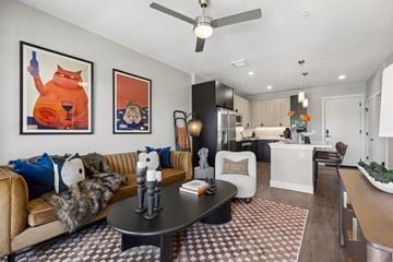 Denver apartment for rent - A living room with a brown and white checkered rug and a brown leather couch.