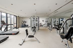 Huntsville apartment for rent - a gym with cardio equipment and weights on the floor