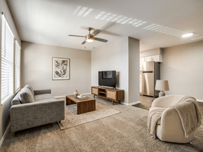 Georgetown apartment for rent - A living room with a grey couch, a coffee table, a television, and a ceiling fan.